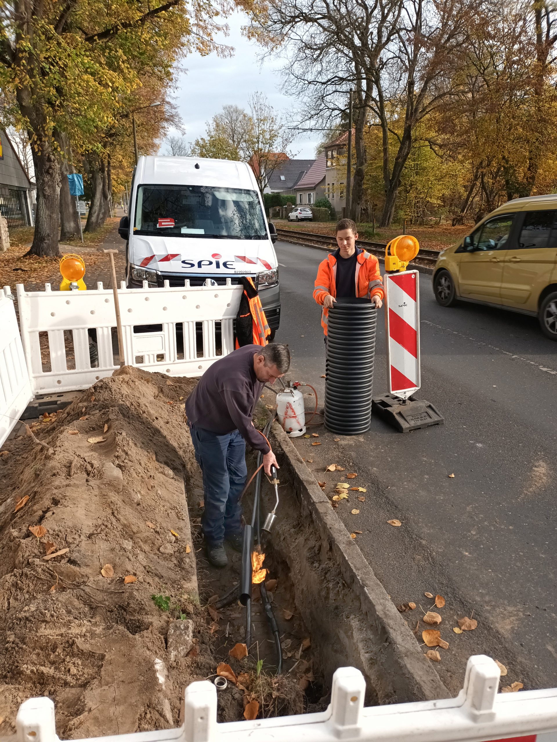 Mitarbeiter der Firma Spie aus LOS bereiten in einem Graben neben der Berliner Straße den Anschluss neuer Straßenlampen vor