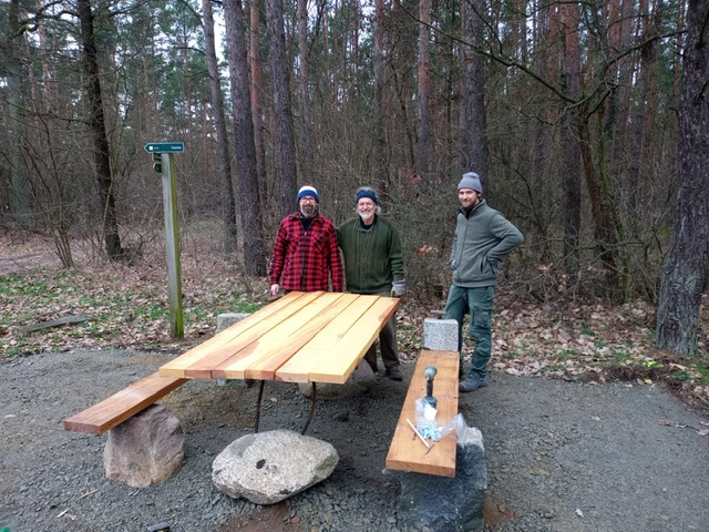 Enrico Meißner, Kurt Zirwes und Stefan Krannich (von links) haben die neue Sitzgrupe aus Feldsteinen und Holz in Gladowshöhe am Waldrand aufgebaut.